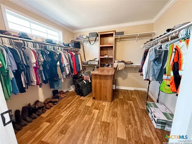 a view of walk in closet with clothes and shoes