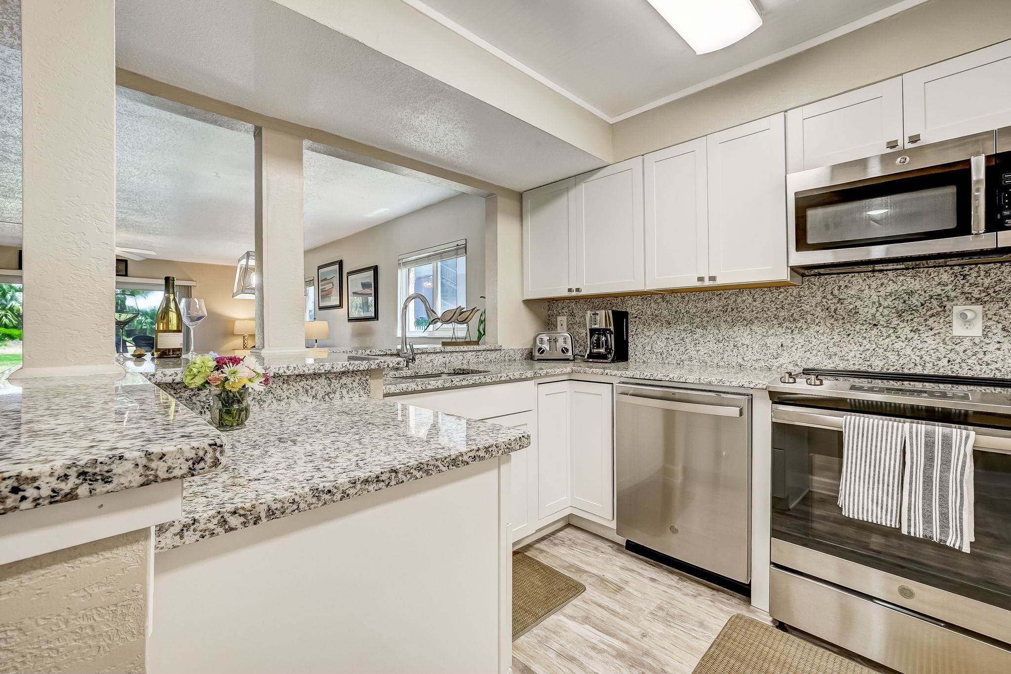 4 Ocean Trace Road, Unit 108 St. Augustine, FL 32080 - Photo 13 of 54 a kitchen with granite countertop a sink and stainless steel appliances