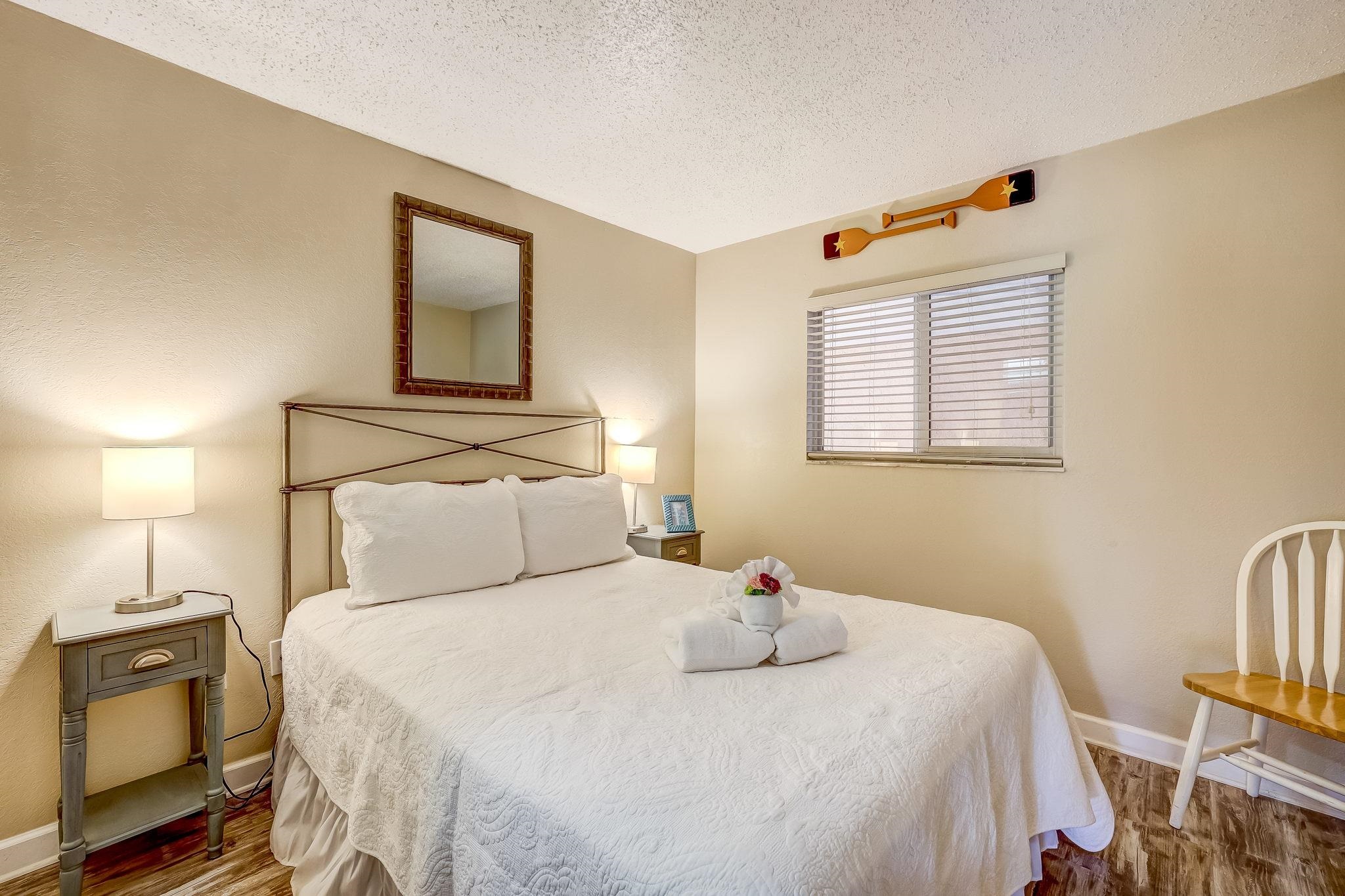 4 Ocean Trace Road, Unit 108 St. Augustine, FL 32080 - Photo 23 of 54 a bedroom with a bed and wooden floor