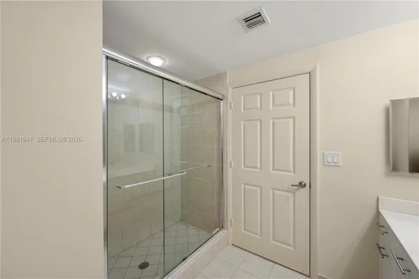 a bathroom with a shower and a glass door