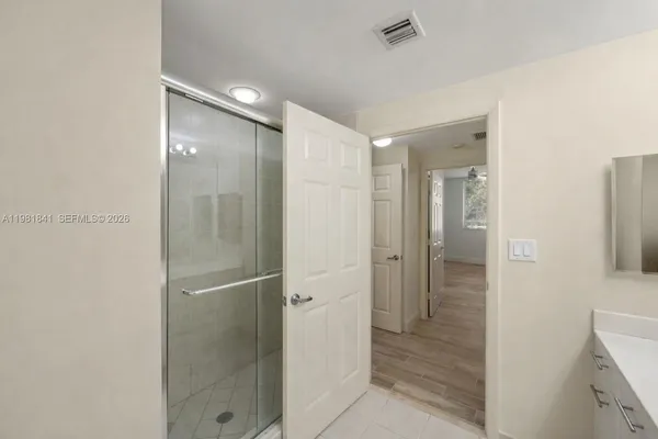 a bathroom with a shower and a glass door