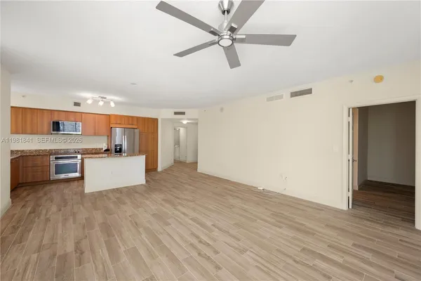 a large kitchen with cabinets wooden floor and stainless steel appliances