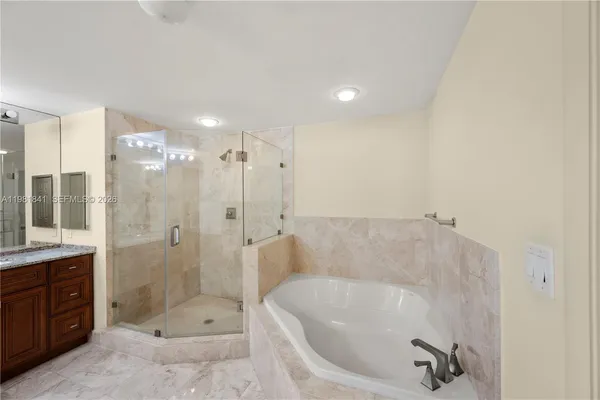 a bathroom with a shower a tub and shower