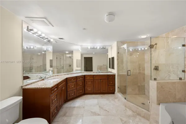 a large bathroom with a large tub shower sink mirror and