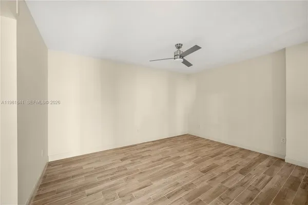a view of a room with wooden floor and white walls
