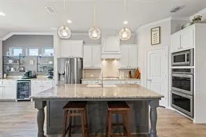 a kitchen with granite countertop a table chairs microwave and cabinets