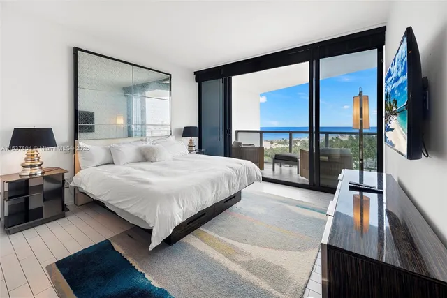 a bedroom with a large bed and a flat tv screen on dresser