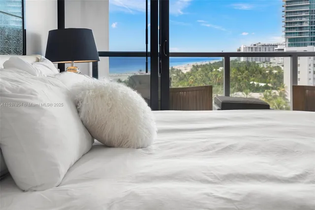 a bed sitting in a bedroom next to a large window with a balcony view