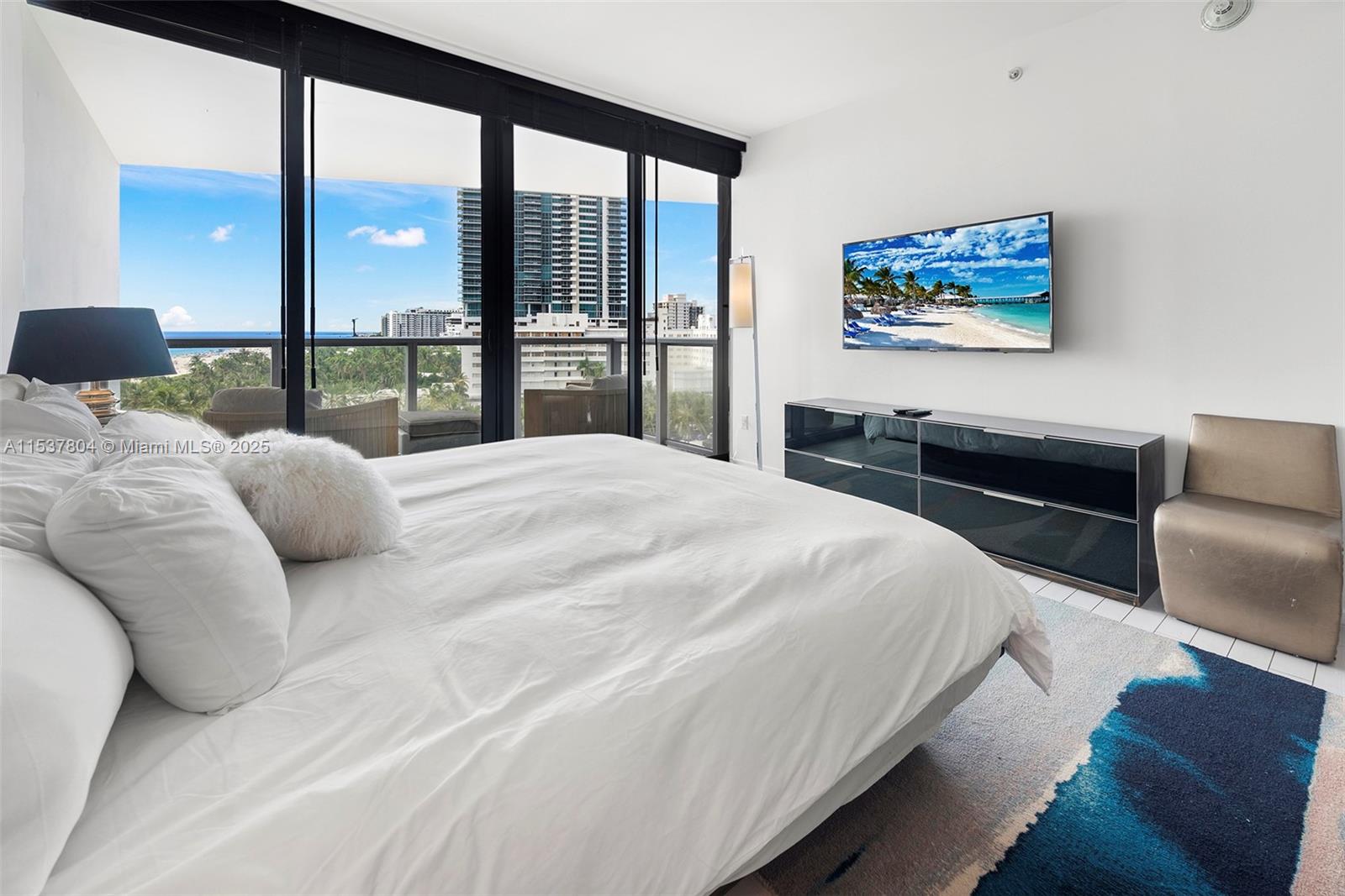 2201 Collins Avenue, Unit 814 Miami Beach, FL 33139 - Photo 17 of 32 a bedroom with a large bed and a couch