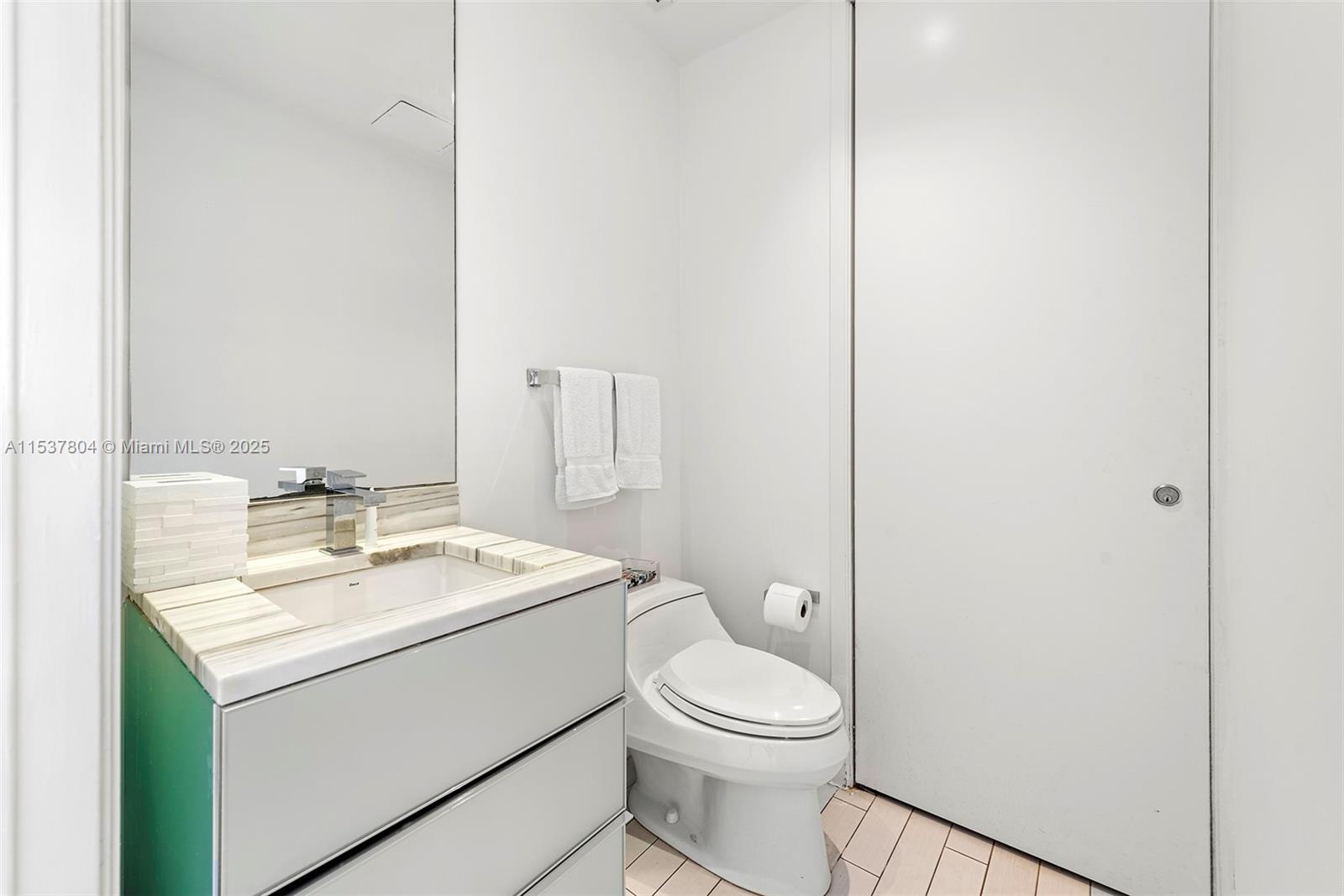 2201 Collins Avenue, Unit 814 Miami Beach, FL 33139 - Photo 26 of 32 a bathroom with a toilet a sink and mirror