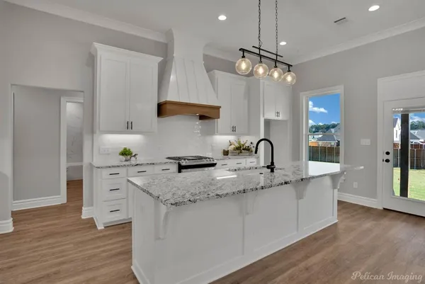 a kitchen with a sink cabinets and wooden floor