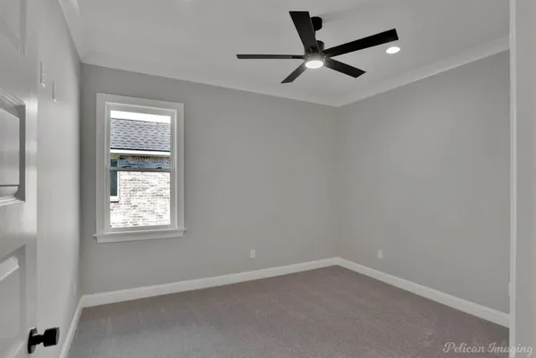 an empty room with a window and a ceiling fan