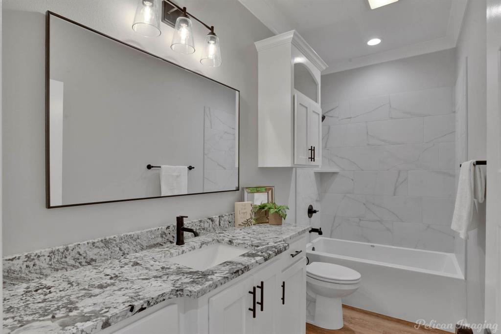 165 Oak Aly Road Stonewall, LA 71078 - Photo 25 of 36 a bathroom with a granite countertop sink a toilet and bathtub
