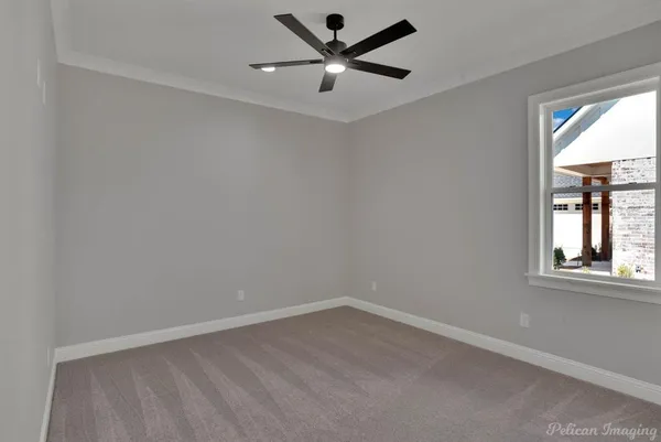 an empty room with a window and a fan