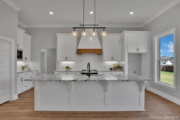 a kitchen with kitchen island granite countertop a sink a counter space and cabinets