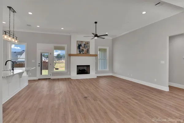 a view of a livingroom with a fireplace a chandelier and wooden floor