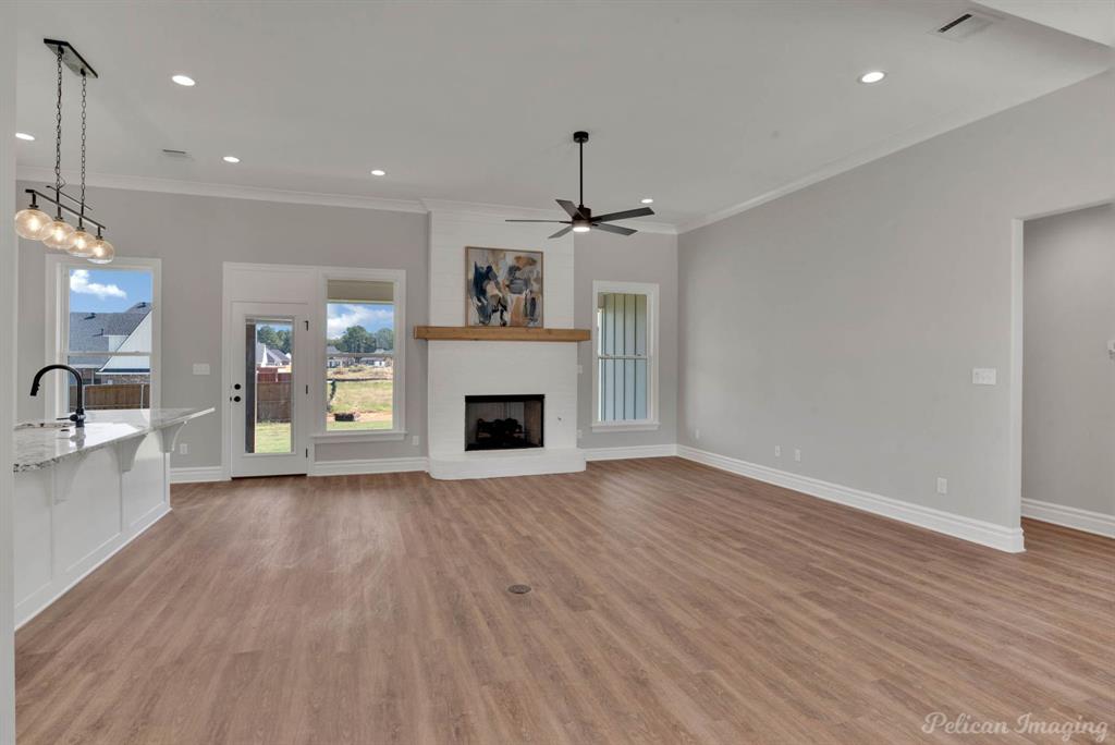 165 Oak Aly Road Stonewall, LA 71078 - Photo 8 of 36 a view of a livingroom with a fireplace a chandelier and wooden floor