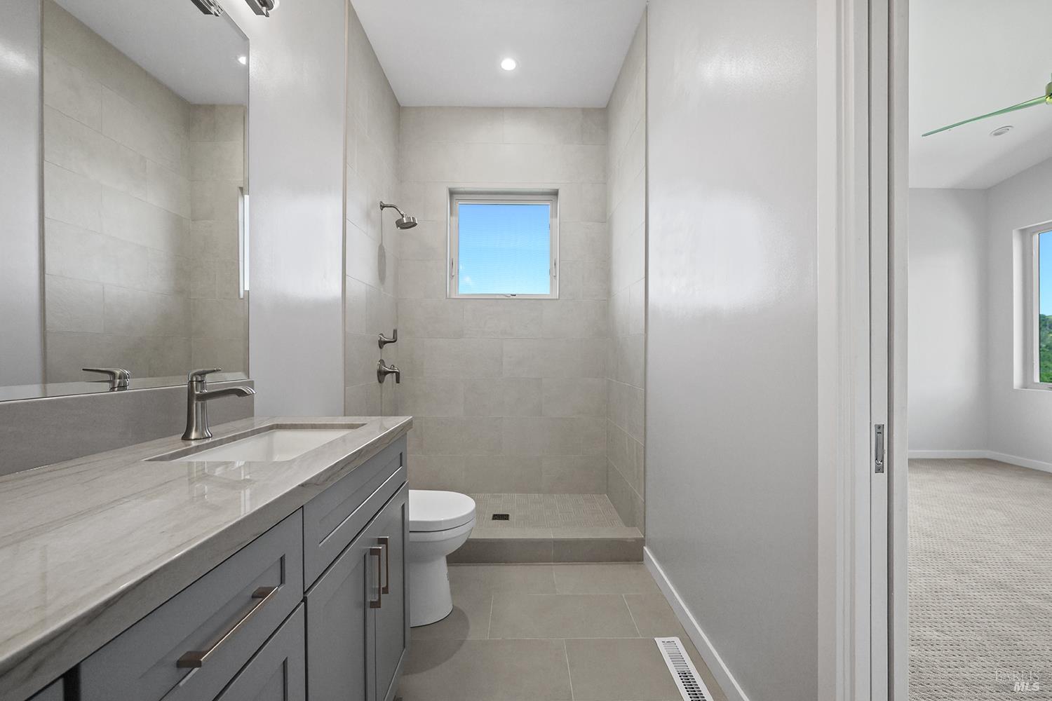 1292 Wikiup Drive Santa Rosa, CA 95403 - Photo 23 of 32 a bathroom with a granite countertop sink a toilet and a mirror