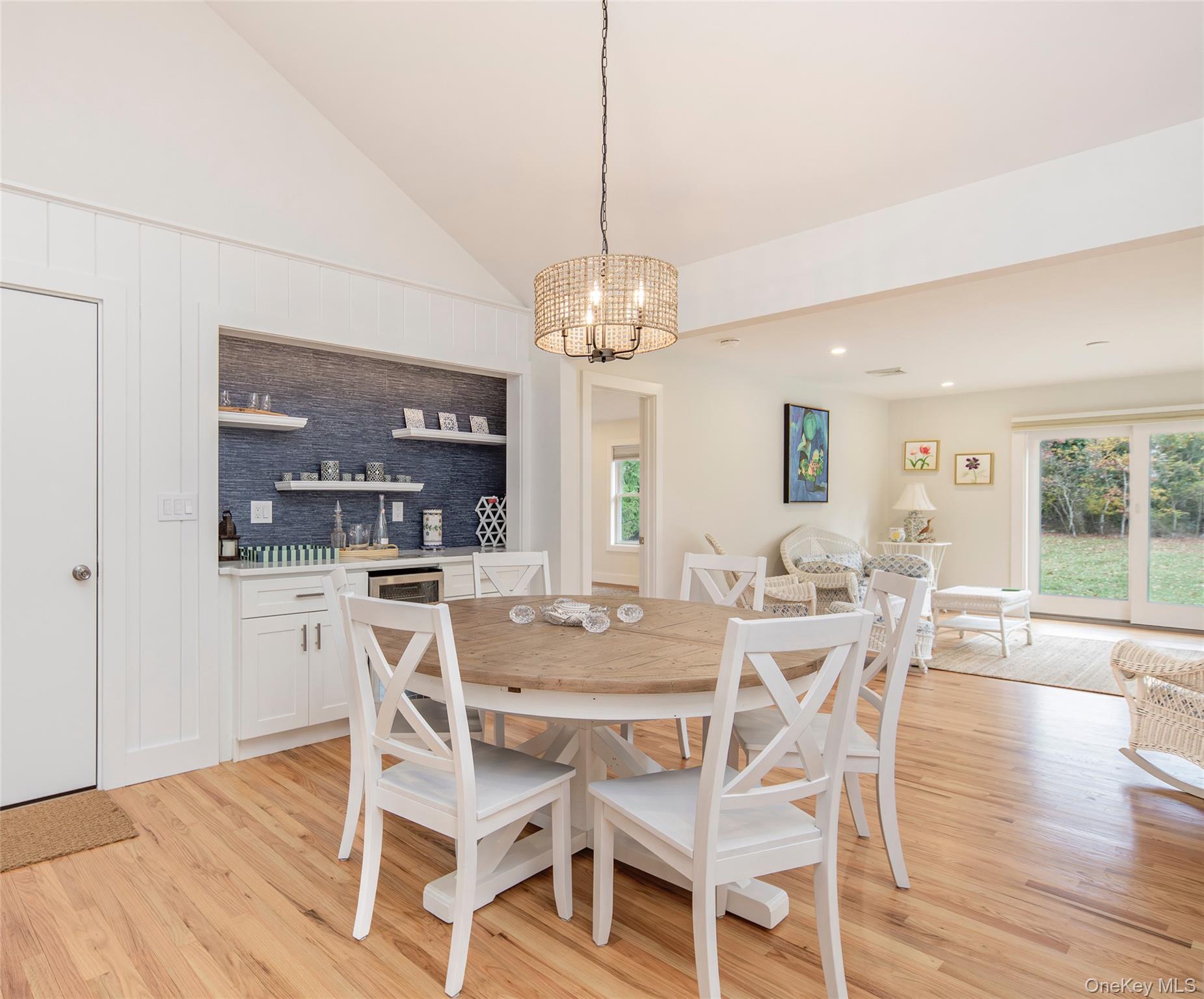 Dining space featuring vaulted ceiling, a chandelier, light wood finished floors, and recessed lighting