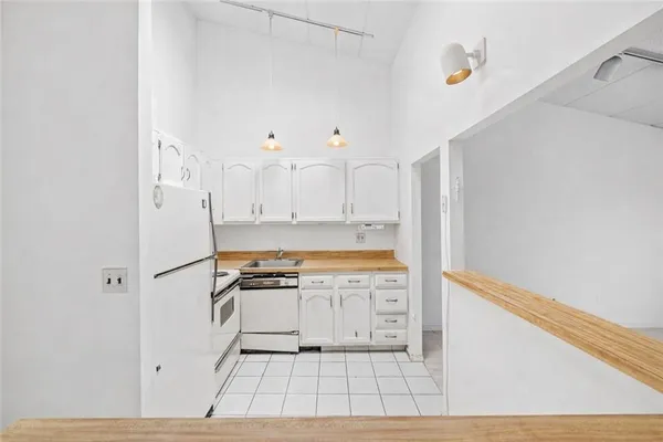 a kitchen with white cabinets and white appliances