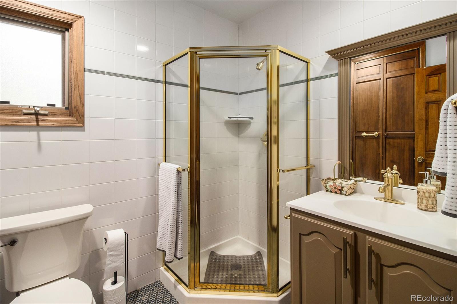 28433 Kinnikinnick Road Evergreen, CO 80439 - Photo 14 of 29 a bathroom with a sink a toilet and shower