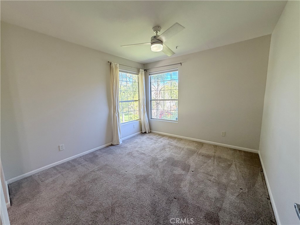 375 Central Avenue, Unit 14 Riverside, CA 92507 - Photo 17 of 32 an empty room with windows and chandelier fan