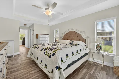 a large bed sitting in a bedroom next to a window with a chandelier