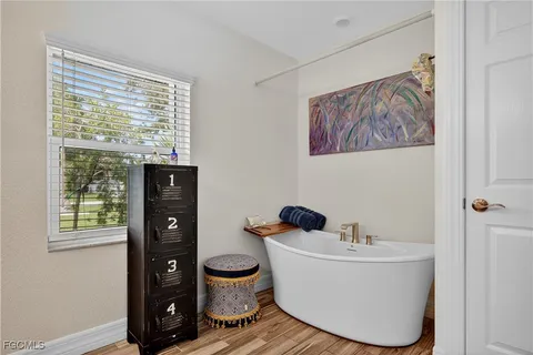 a white bath tub sitting in a bathroom next to a window