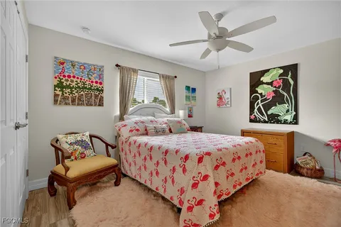 a bedroom with a bed and painting on the wall