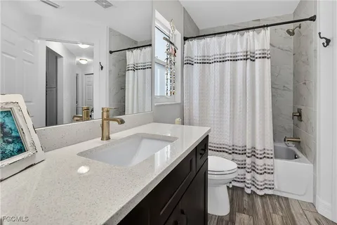 a bathroom with a granite countertop sink a mirror and a shower