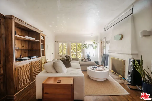 a living room with furniture a fireplace and a large window