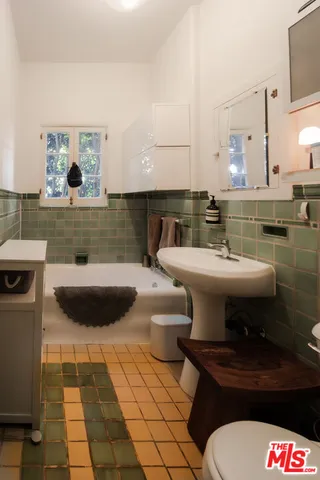 a bathroom with a sink a toilet and mirror