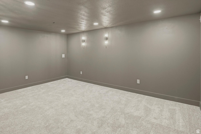 8760 Rustler Road Cottonwood Heights, UT 84093 - Photo 37 of 57 Spacious room featuring neutral wall tones, recessed ceiling lighting, textured carpet flooring, and modern wall sconces