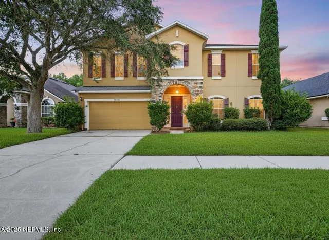 a front view of a house with garden and plants