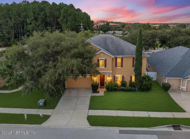 a front view of a house with a garden and yard