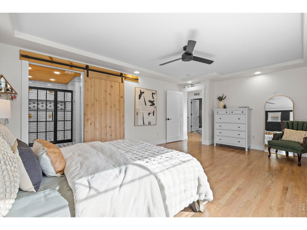 148 Summit Way Erie, CO 80516 - Photo 22 of 47 a spacious bedroom with a bed a dresser and wooden floor