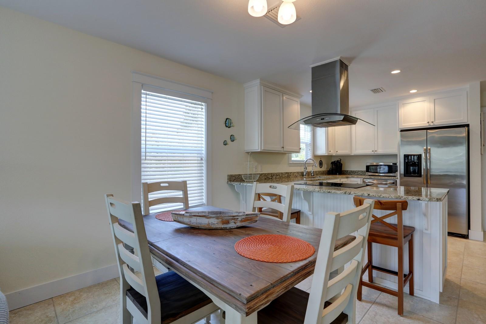 97 Sand Dunes Road Santa Rosa Beach, FL 32459 - Photo 16 of 31 a kitchen with stainless steel appliances granite countertop a kitchen island a stove a table and chairs
