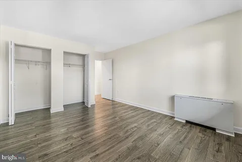 an empty room with wooden floor and window