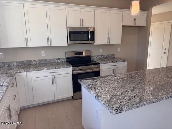 a kitchen with stainless steel appliances granite countertop a sink stove and microwave