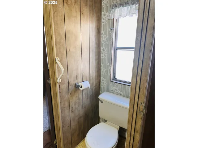 a bathroom with a toilet and a shower curtain
