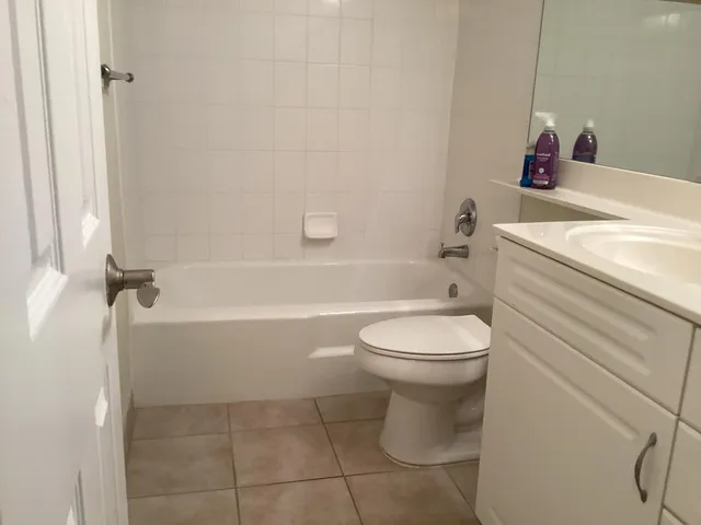 a white bath tub sitting next to a white sink and a toilet