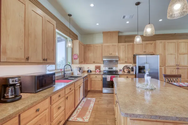 a large kitchen with stainless steel appliances granite countertop a sink counter space cabinets and a large window