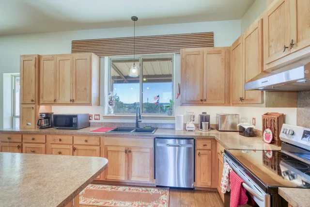 a kitchen with stainless steel appliances a sink stove and cabinets
