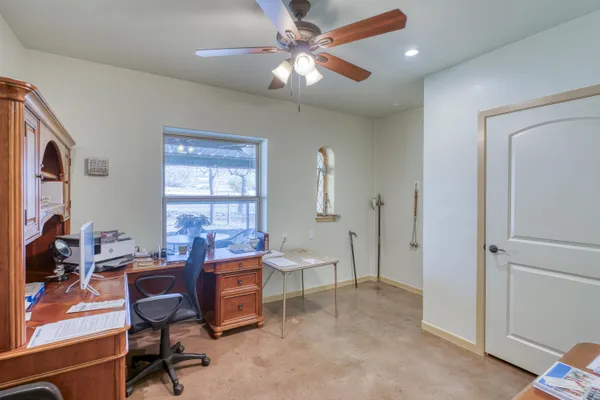 a view of a workspace with furniture and a window