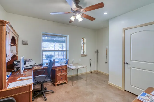 a view of a workspace with furniture and a window