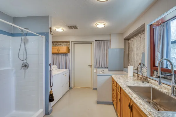 a bathroom with a granite countertop sink a mirror a shower and a bathtub