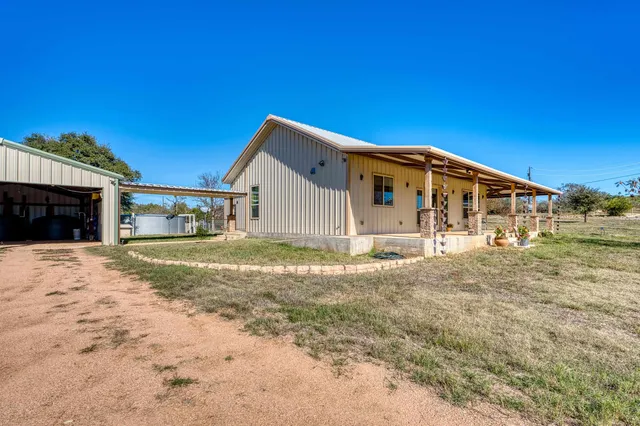 a view of a house with backyard and sitting area
