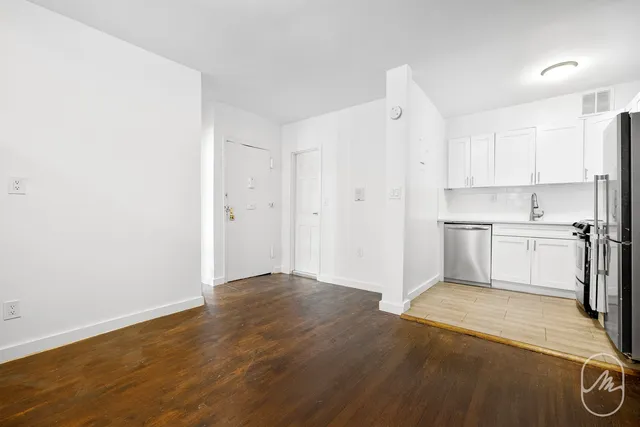 a view of a kitchen with a sink and a refrigerator
