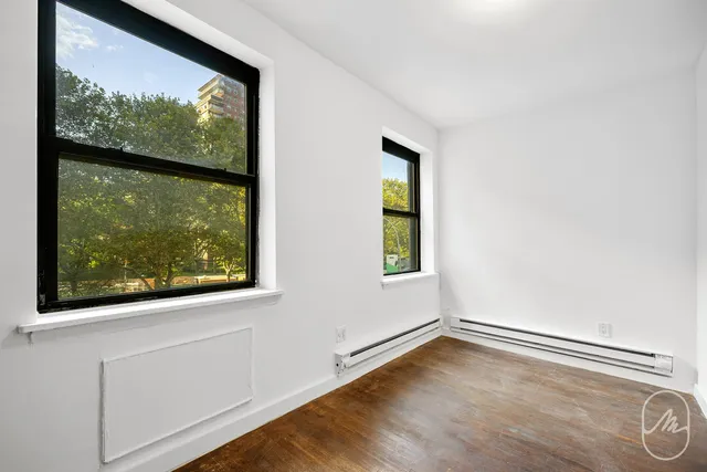 a view of a room with a window and wooden floor