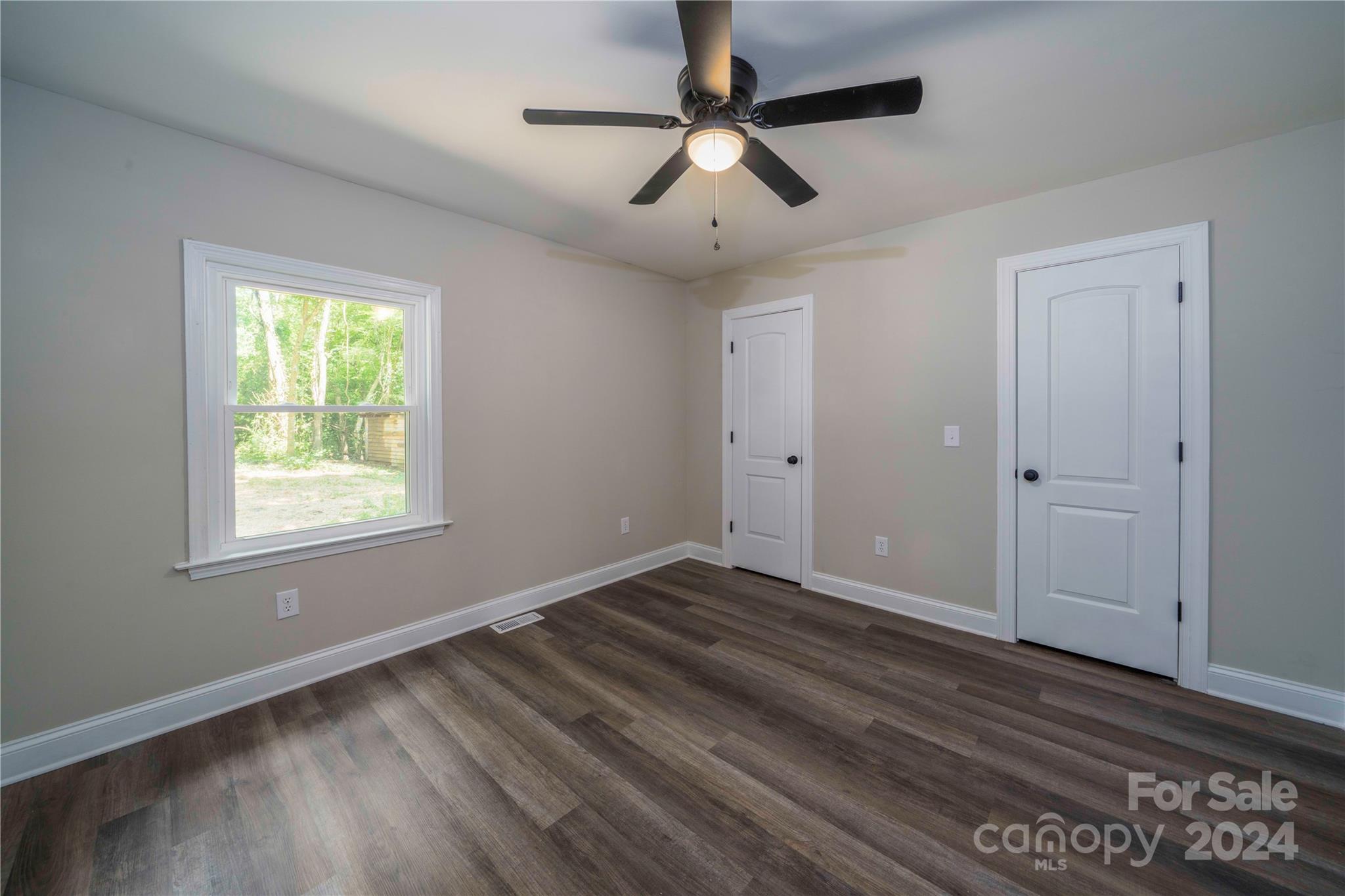 8225 Woodleaf Road Woodleaf, NC 27054 - Photo 23 of 40 a view of empty room with wooden floor and fan
